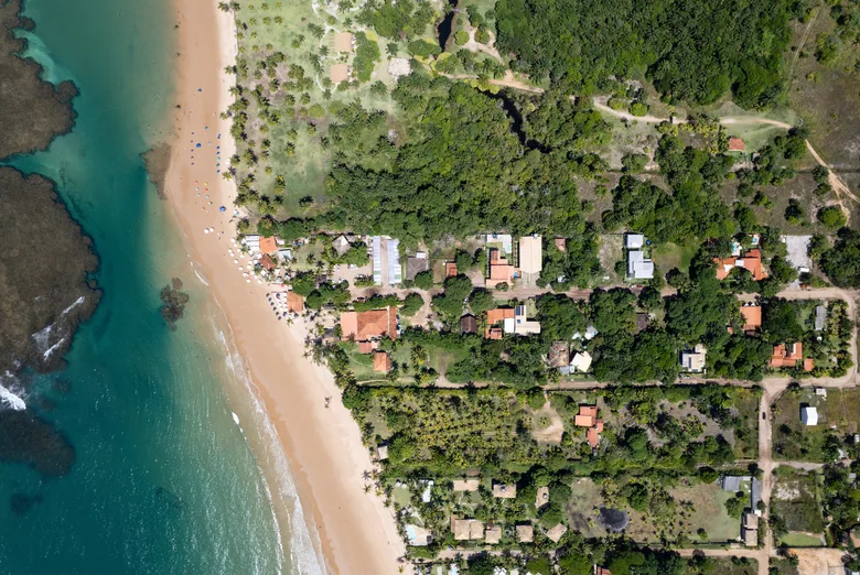 Vista aérea da praia e das casas de Taipu de Fora, entre o mar e a mata