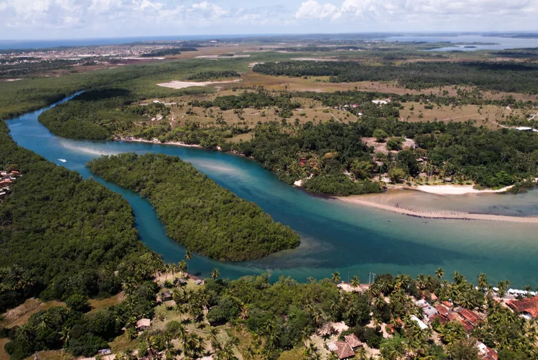 Vista aérea da foz de um rio entre a mata e o mar, na Península de Maraú